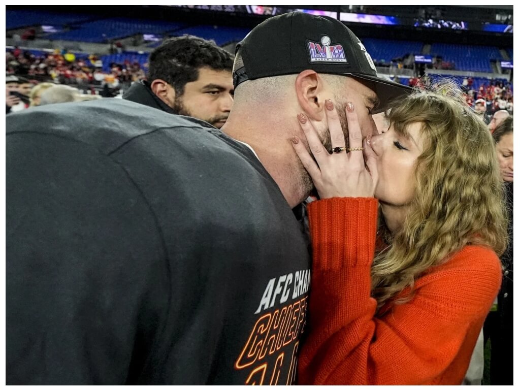 Taylor Swift kisses Travis Kelce.